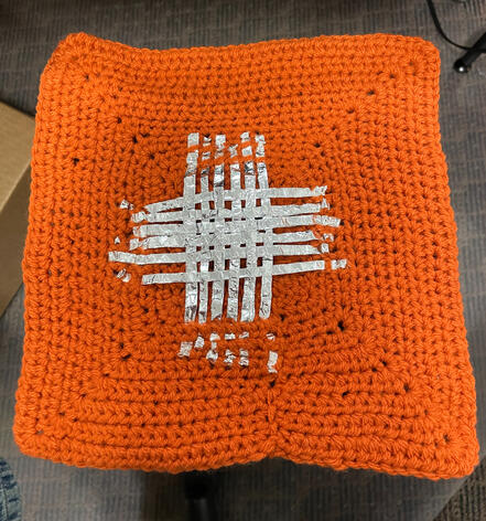 A crocheted square with woven aluminum strips to connect the Makey Makey circuit.